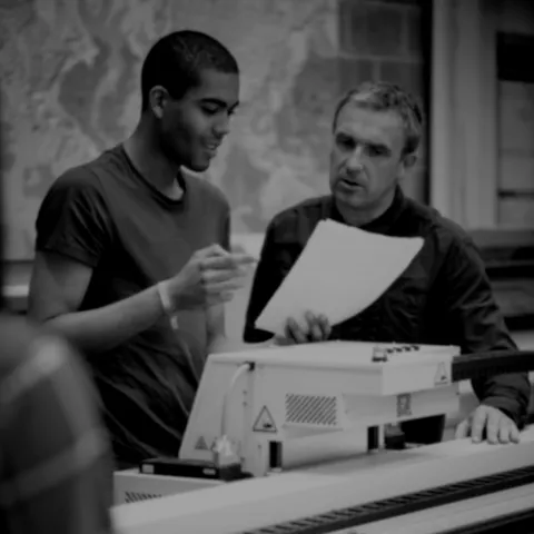 Young man undertaking supervised project work with an instructor.